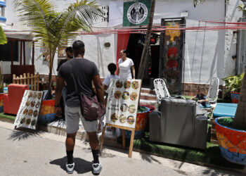 Personas pasando frente al restaurante Starcafe, en La Habana. Foto:  Ernesto Mastrascusa/EFE.
