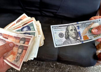 Imagen que simula una transacción en el mercado informal de divisas en Cuba, en el que el dólar ha mantenido un ascenso progresivo a lo largo de 2025 hasta superar los 400 pesos de valor. Foto: Ernesto Mastrascusa / EFE.