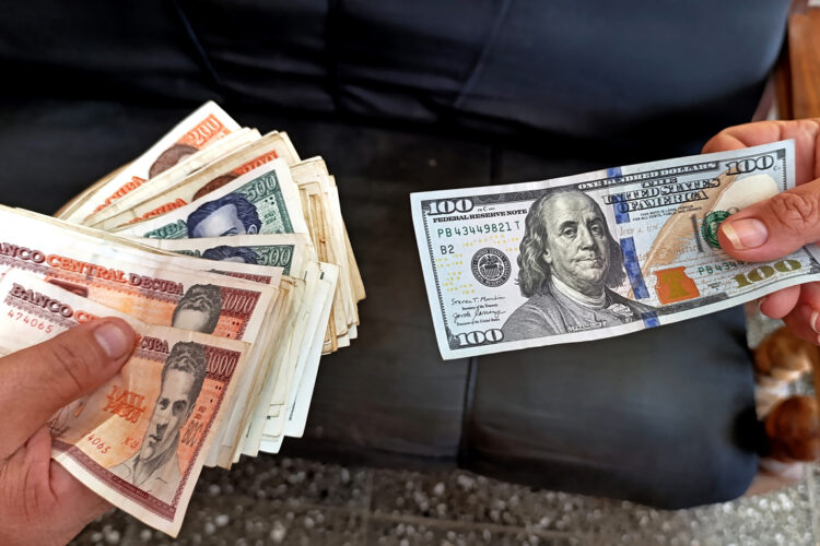 Imagen que simula una transacción en el mercado informal de divisas en Cuba, en el que el dólar ha mantenido un ascenso progresivo a lo largo de 2025 hasta superar los 400 pesos de valor. Foto: Ernesto Mastrascusa / EFE.