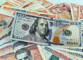Un billete de 100 dólares junto a billetes de varias denominaciones de pesos cubanos. Foto: Ernesto Mastrascusa / EFE / Archivo.