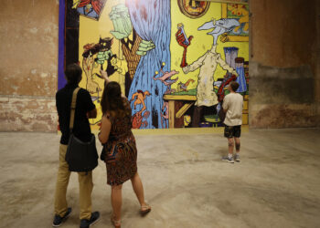 Personas observan la exposición por el 40 aniversario de la película "Vampiros en La Habana" en la sede de la Galería Continua, en La Habana. Foto: Ernesto Mastrascusa / EFE.