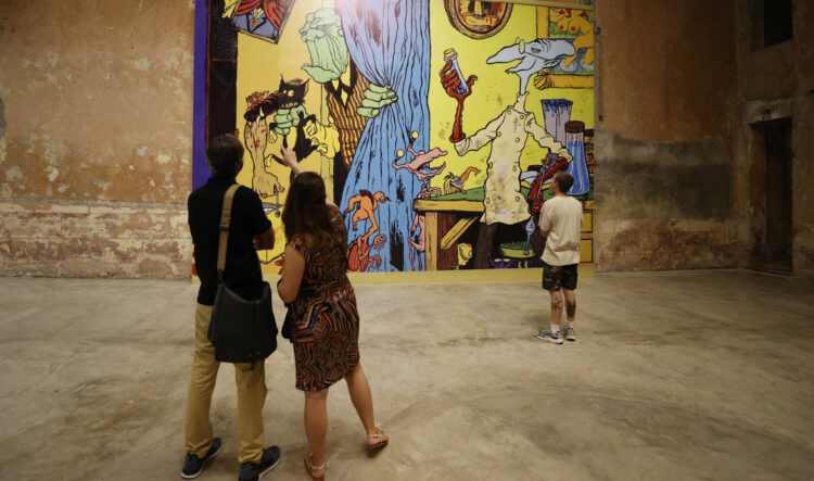 Personas observan la exposición por el 40 aniversario de la película "Vampiros en La Habana" en la sede de la Galería Continua, en La Habana. Foto: Ernesto Mastrascusa / EFE.