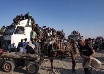 Palestinos desplazados internos suben a camiones de ayuda humanitaria para conseguir comida cerca de un punto de distribución de alimentos en el corredor de Morag este lunes, al sur de Jan Yunis. Foto: HAITHAM IMAD/EFE/EPA.