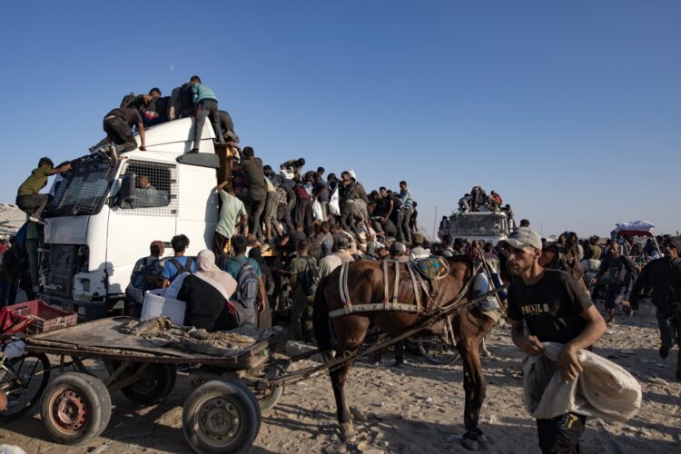 Palestinos desplazados internos suben a camiones de ayuda humanitaria para conseguir comida cerca de un punto de distribución de alimentos en el corredor de Morag este lunes, al sur de Jan Yunis. Foto: HAITHAM IMAD/EFE/EPA.