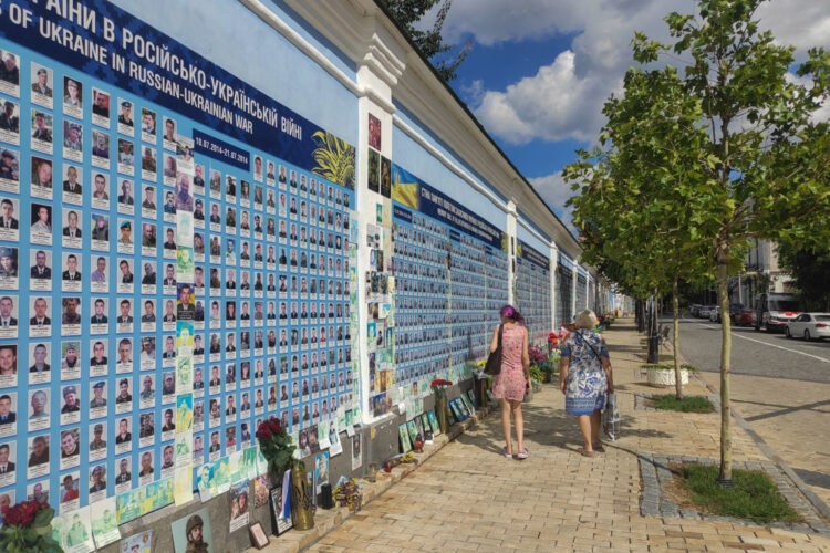 Dos personas caminan junto a un monumento conmemorativo a los soldados ucranianos. Los ucranianos esperan poner fin a la guerra mediante la diplomacia y algunos considerarían ceder temporalmente los territorios ocupados por Rusia a cambio de garantías de seguridad fiables, pero la mayoría comparte la postura del Gobierno de que no se pueden ceder zonas actualmente controladas por Ucrania a cambio de una incierta paz como exige Moscú. "Lo que temo es que Donald Trump y Vladímir Putin acuerden algo a nuestras espaldas, que luego intentarán imponernos", declaró a EFE Zoreslava Taraj, profesora de inglés en la ciudad occidental ucraniana Leópolis, en referencia a la reunión prevista entre los líderes de Estados Unidos y Rusia el viernes en Alaska. Foto: EFE/ Rostyslav Averchuk.