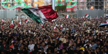 Una multitud abarrota la Plaza de la Constitución durante la ceremonia por el 215 aniversario del Grito de Independencia desde el Palacio Nacional en Ciudad de México. Foto: Mario Guzmán/EFE.