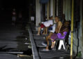 Personas sentadas fuera de sus casas durante un apagón nocturno en La Habana. Foto: Ernesto Mastrascusa / EFE.