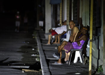 Personas sentadas fuera de sus casas durante un apagón nocturno en La Habana. Foto: Ernesto Mastrascusa / EFE.