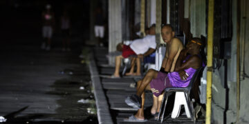Personas sentadas fuera de sus casas durante un apagón nocturno en La Habana. Foto: Ernesto Mastrascusa / EFE.