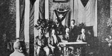 Foto tomada el 10 de octubre de 1892 en la que aparece Martí presidiendo el Cuerpo del Consejo de Kingston. Se observan desplegadas a su derecha la bandera de Cuba y a su izquierda la de Puerto Rico. Foto: Iconografía Martiana.