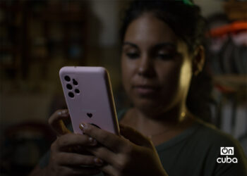 Una joven revisa su teléfono celular durante un apagón en La Habana. Foto: Otmaro Rodríguez.