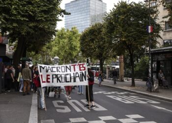 Un grupo de manifestantes en Francia exhibe una pancarta en la que piden la renuncia del presidente Emmanuel Macron. Foto: Teresa Suárez / EFE / EPA.