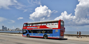 Un ómnibus de turismo transita prácticamente sin turistas por una zona del malecón habanero. Foto: Ernesto Mastrascusa / EFE.