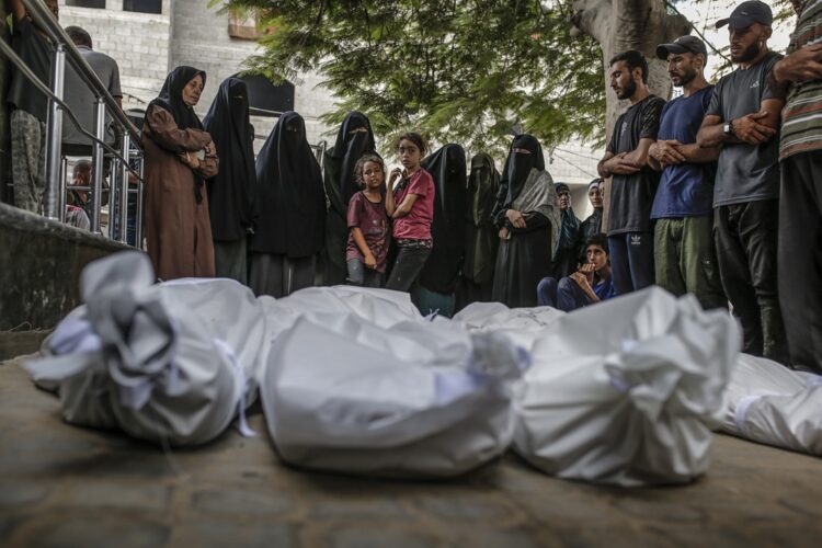 Palestinos rezan junto a los cuerpos cubiertos de familiares muertos por ataques de Israel, en el hospital Al Shifa de la ciudad de Gaza. Foto: Mohammed Saber / EFE / EPA.