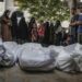 Palestinos rezan junto a los cuerpos cubiertos de familiares muertos por ataques de Israel, en el hospital Al Shifa de la ciudad de Gaza. Foto: Mohammed Saber / EFE / EPA.