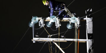 Un trabajador labora en un poste de energía eléctrica durante un apagón en La Habana. Foto: Ernesto Mastrascusa / EFE.