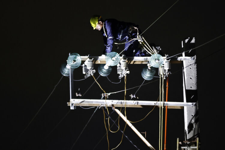 Un trabajador labora en un poste de energía eléctrica durante un apagón en La Habana. Foto: Ernesto Mastrascusa / EFE.