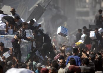 Palestinos recogen ayuda humanitaria de un camión que llegó a Khan Yunis, en el sur de la Franja de Gaza, el 12 de octubre de 2025. Foto: EFE/EPA/HAITHAM IMAD