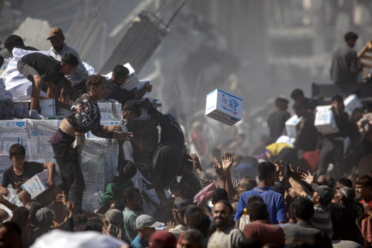 Palestinos recogen ayuda humanitaria de un camión que llegó a Khan Yunis, en el sur de la Franja de Gaza, el 12 de octubre de 2025. Foto: EFE/EPA/HAITHAM IMAD