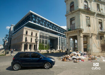 Un auto pasa frente a un vertedero de basura en las cercanías del Paseo del Prado y el hotel Iberostar Grand Packard, en La Habana. Foto: Otmaro Rodríguez.
