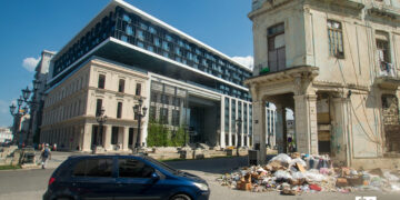 Un auto pasa frente a un vertedero de basura en las cercanías del Paseo del Prado y el hotel Iberostar Grand Packard, en La Habana. Foto: Otmaro Rodríguez.