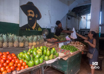 Un vendedor le entrega su compra a una cliente en el mercado agropecuario en la calle Empedrado, en La Habana. Foto: Otmaro Rodríguez.