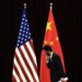 Un funcionario chino camina junto a las banderas nacionales de EE.UU. y China, en una fotografía de archivo. Foto: Andy Wong / EFE / EPA / Archivo.