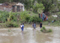 Personas cruzan un río crecido en el municipio de Guamá en Santiago de Cuba, tras el paso del potente huracán Melissa. Foto: Ernesto Mastrascusa / EFE.