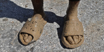 Los pies llenos de lodo de una persona en el poblado de Guamá, Santiago de Cuba, tras el paso del huracán Melissa. Foto: EFE/ Ernesto Mastrascusa.