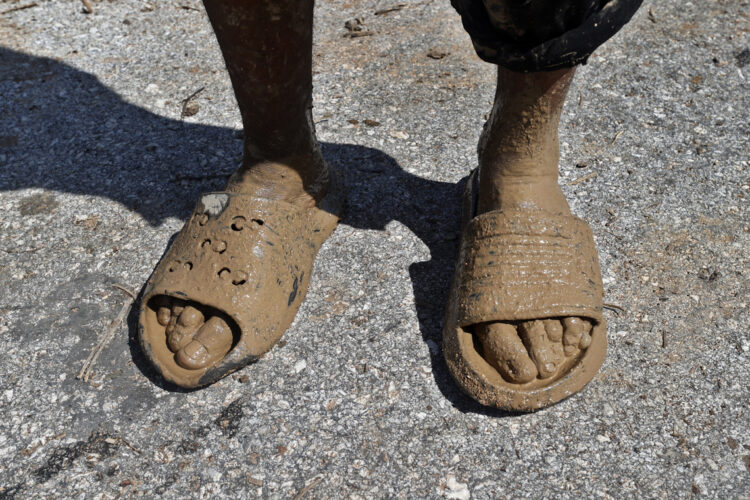 Los pies llenos de lodo de una persona en el poblado de Guamá, Santiago de Cuba, tras el paso del huracán Melissa. Foto: EFE/ Ernesto Mastrascusa.