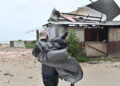 Un hombre carga una lona para cubrir el techo de una casa antes del paso del huracán Melissa, en la playa pesquera de Hellshire, en Portmore, Jamaica. Foto: Rudolph Brown/EFE.