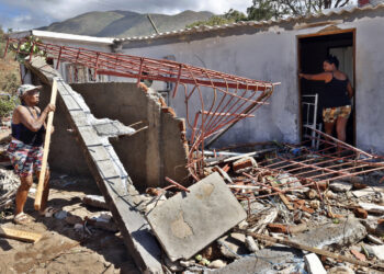 Personas en una casa destruida por el huracán Melissa en el municipio de Guamá, en Santiago de Cuba. Foto: Ernesto Mastrascusa / EFE.