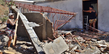 Personas en una casa destruida por el huracán Melissa en el municipio de Guamá, en Santiago de Cuba. Foto: Ernesto Mastrascusa / EFE.