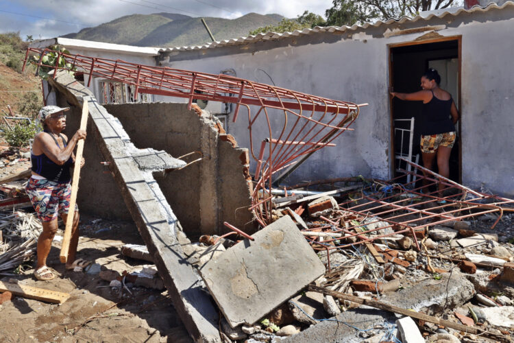 Personas en una casa destruida por el huracán Melissa en el municipio de Guamá, en Santiago de Cuba. Foto: Ernesto Mastrascusa / EFE.