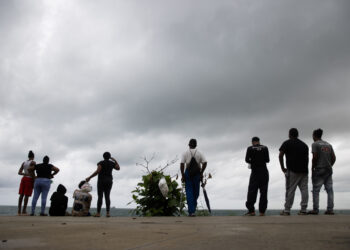 25/10/2025.- Personas observan las labores de búsqueda de un adolescente de 13 años que desapareció en aguas del Caribe, durante el paso del huracán Melissa este sábado, en Santo Domingo (República Dominicana). Foto: EFE/ Orlando Barría.