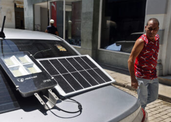 Un hombre observa un panel solar suministrando energía a una lámpara, durante un apagón en La Habana. Foto: Ernesto Mastrascusa / EFE / Archivo.