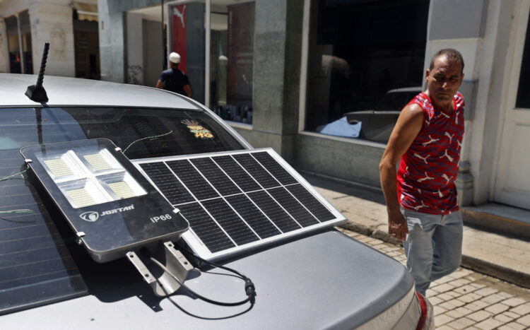 Un hombre observa un panel solar suministrando energía a una lámpara, durante un apagón en La Habana. Foto: Ernesto Mastrascusa / EFE / Archivo.