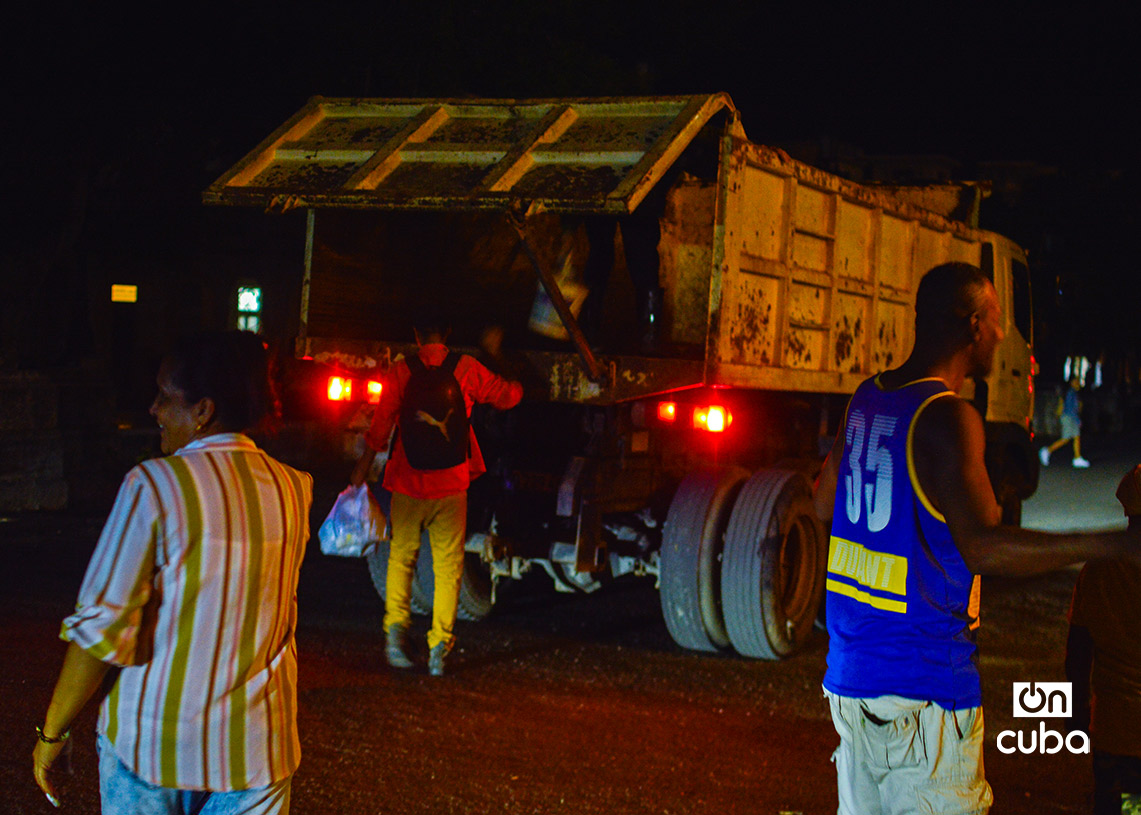 Habaneros llevan sus bolsas de basura hasta un camión colector. Foto: Otmaro Rodríguez.