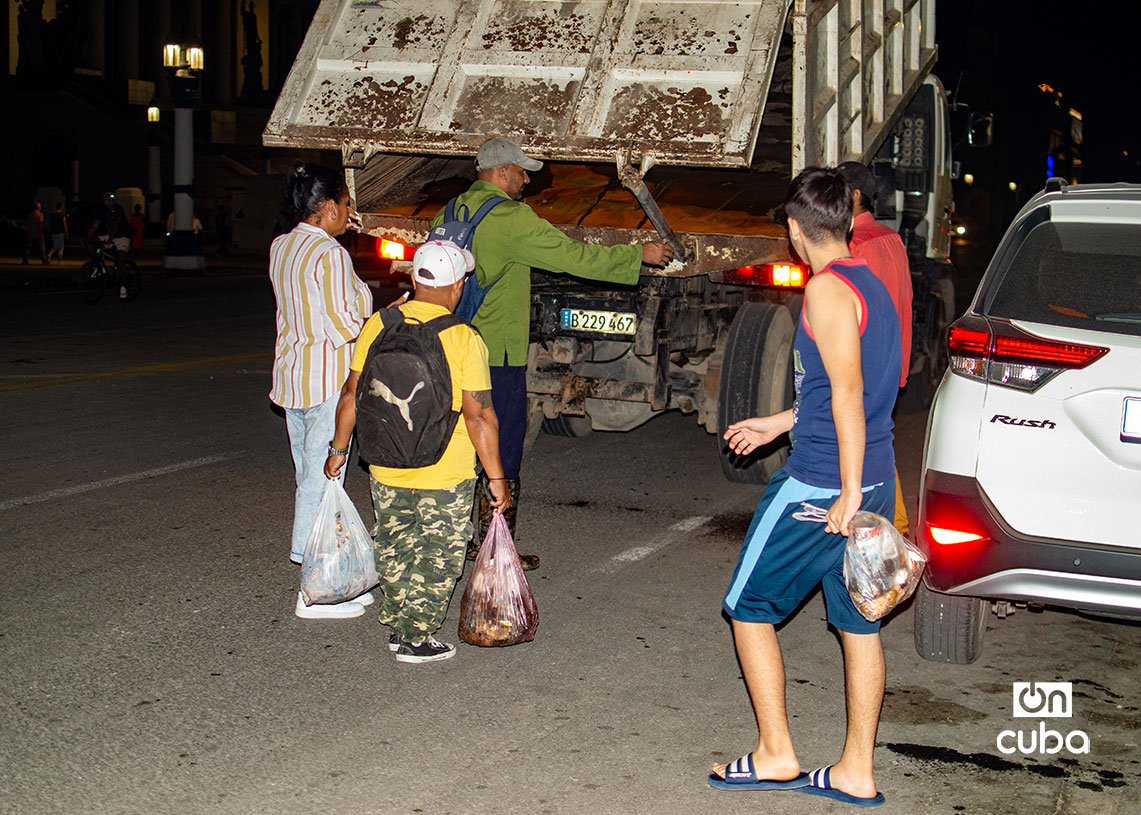 Habaneros llevan sus bolsas de basura hasta un camión colector. Foto: Otmaro Rodríguez.
