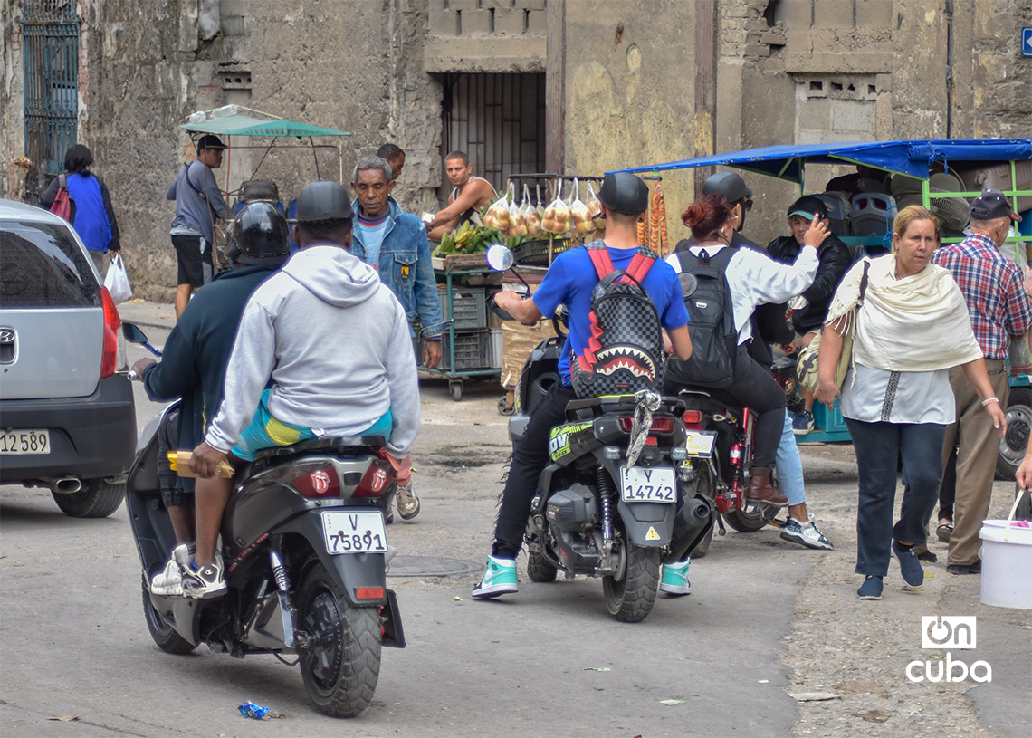 Personas y motos eléctricas en La Habana. Foto: Otmaro Rodríguez.