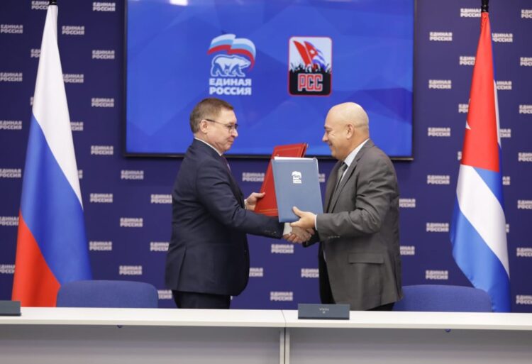 El secretario de organización del PCC, Roberto Morales Ojeda, saluda al secretario del Consejo General de Rusia Unida, Vladimir Yakushev, tras la firma de un acuerdo entre ambas formaciones políticas, en Moscú, el 27 de noviembre de 2025. Foto: Tomada del perfil en X de Roberto Morales Ojeda.