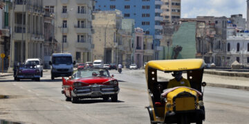 Varios vehículos transitan por una zona del malecón de La Habana, entre ellos autos que se dedican al transporte de turistas. Foto: Ernesto Mastrascusa / EFE / Archivo.