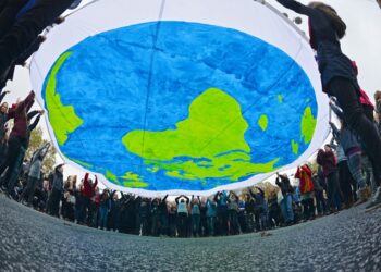 Manifestantes sostienen una pancarta con la imagen del planeta Tierra durante la jornada inaugural de la Conferencia de las Naciones Unidas sobre el Cambio Climático (COP23), celebrada en Bonn, Alemania, el 6 de noviembre de 2017 (reeditada el 7 de noviembre de 2025). Foto: EFE/EPA/Philipp Guelland.