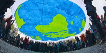 Manifestantes sostienen una pancarta con la imagen del planeta Tierra durante la jornada inaugural de la Conferencia de las Naciones Unidas sobre el Cambio Climático (COP23), celebrada en Bonn, Alemania, el 6 de noviembre de 2017 (reeditada el 7 de noviembre de 2025). Foto: EFE/EPA/Philipp Guelland.