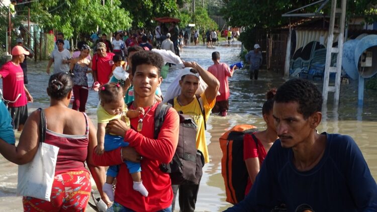 Personas siendo evacuadas en Río Cauto por las fuertes inundaciones. Foto: CMKX Radio Bayamo