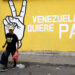 Un hombre camina frente a un mural, en Caracas. Foto:  Ronald Peña R/EFE.