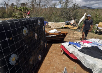 Una persona posa junto a pertenencias que le han quedado tras el paso de Melissa, en Guamá, Santiago de Cuba. Foto: Ernesto Mastrascusa/EFE.