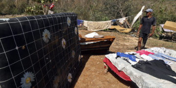 Una persona posa junto a pertenencias que le han quedado tras el paso de Melissa, en Guamá, Santiago de Cuba. Foto: Ernesto Mastrascusa/EFE.