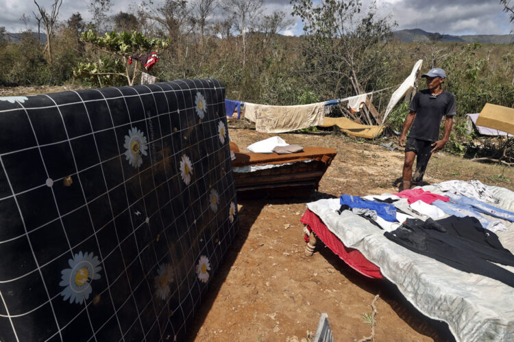 Una persona posa junto a pertenencias que le han quedado tras el paso de Melissa, en Guamá, Santiago de Cuba. Foto: Ernesto Mastrascusa/EFE.