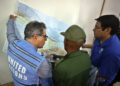 El representante de la ONU en Cuba, Francisco Pichon (i), intercambia con otras autoridades y observa un mapa para realizar un sobrevuelo por las zonas afectadas por el huracán Melissa en el oriente de Cuba. Foto: Ernesto Mastrascusa / EFE.